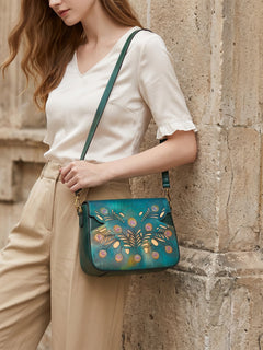Model wearing teal peacock feather leather crossbody bag